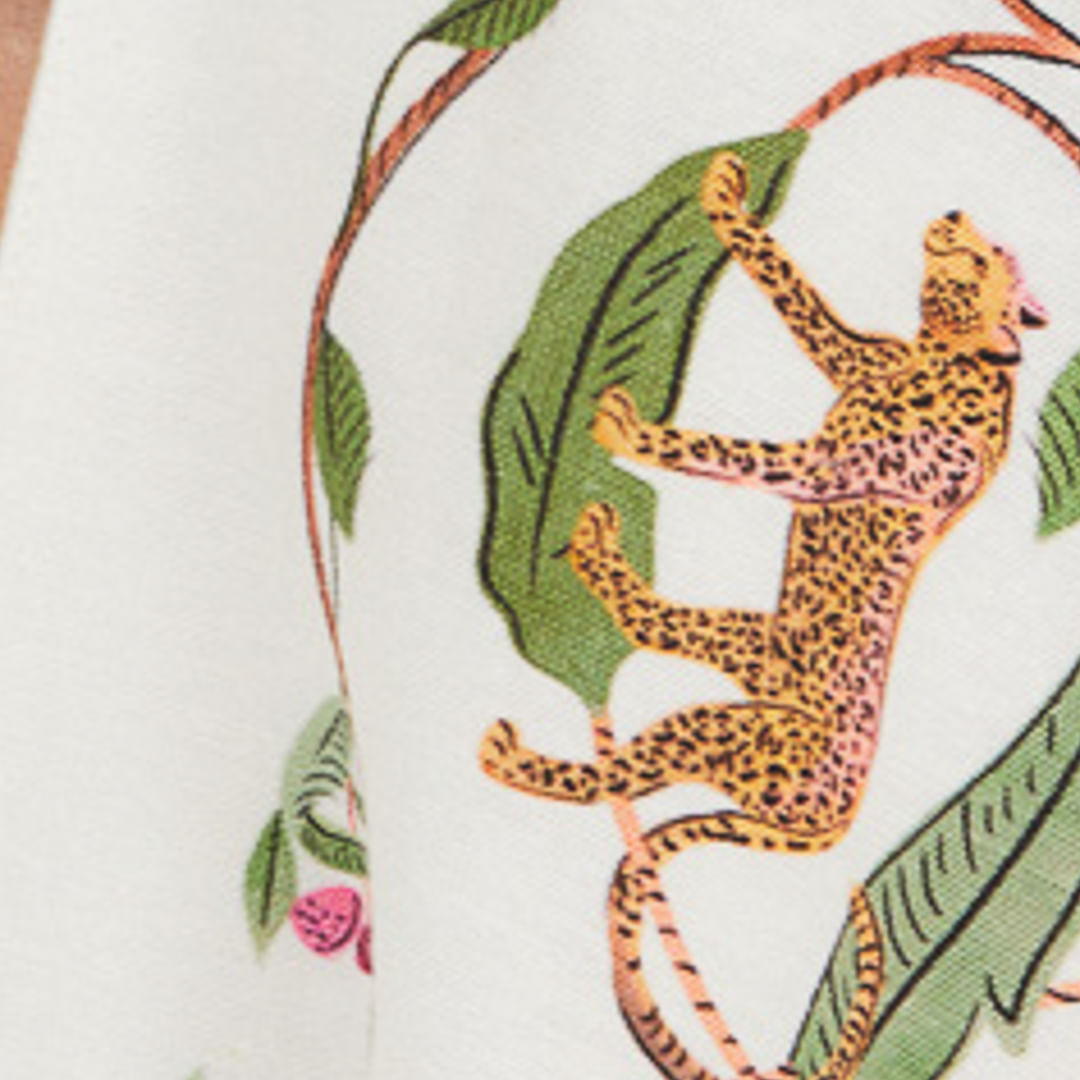 Acercamiento al estampado del kimono Floresta Doce mostrando un leopardo y follaje.