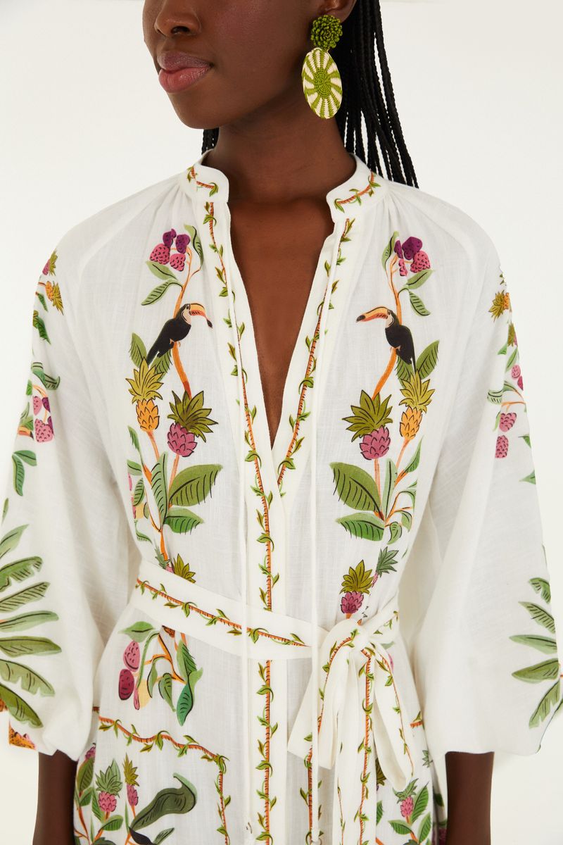 Detalle del escote en V del vestido con estampado tropical.