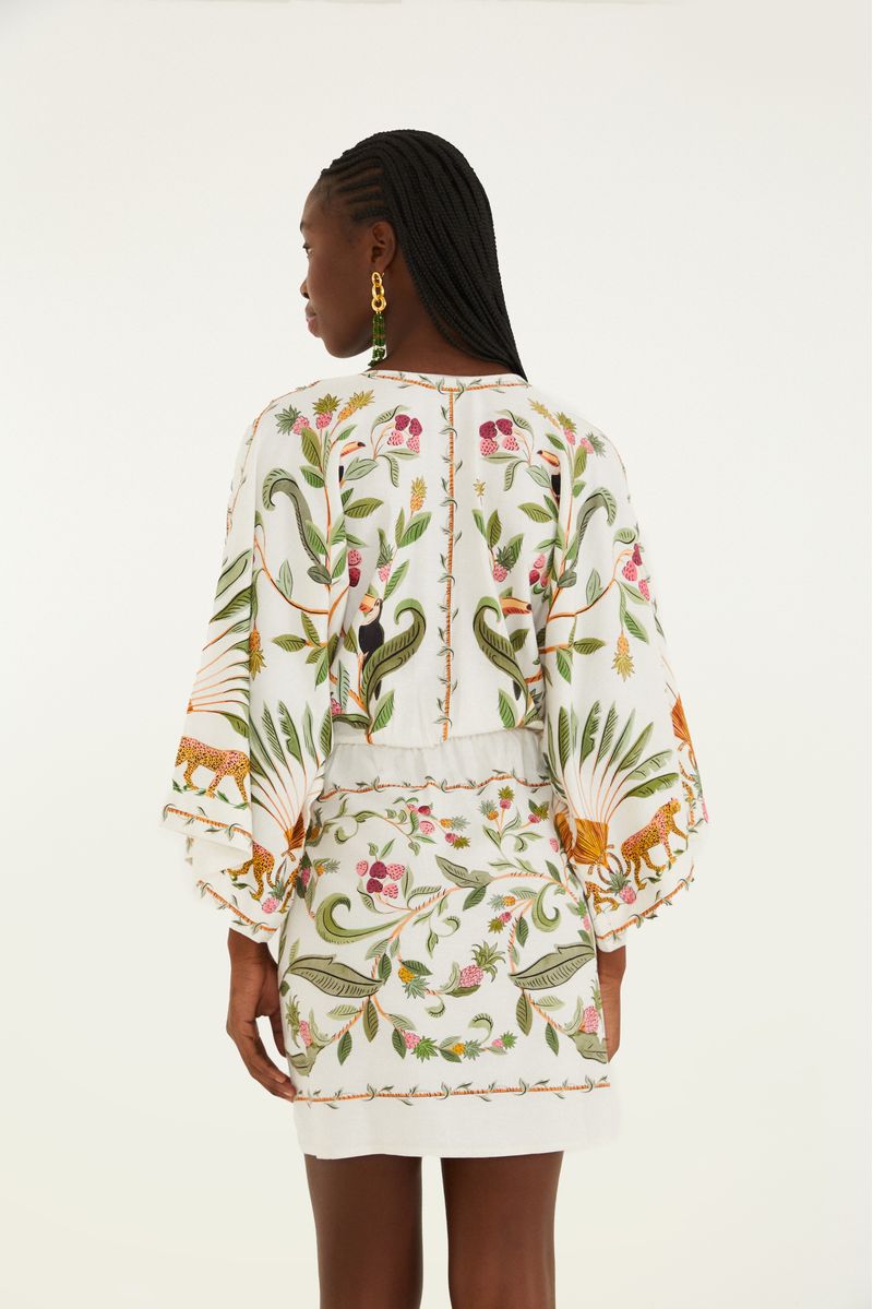 Detalle del escote en V del vestido corto con estampado de bosque dulce, con elementos decorativos.