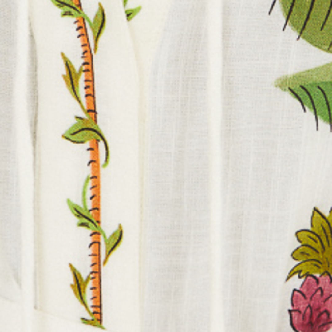 Primer plano del estampado tropical del vestido mostrando elementos botánicos y animales.