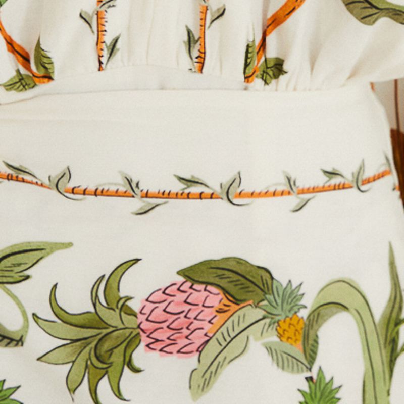 Detalle del estampado de bosque dulce en el vestido corto, con elementos botánicos y animales.