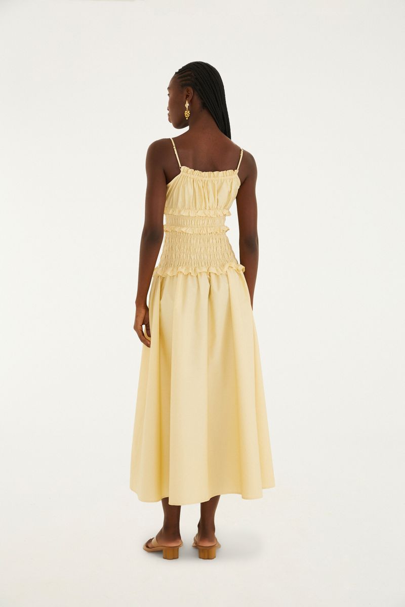 Vestido amarillo con lastex y tirantes delgados, visto desde atrás.