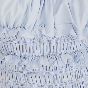 Detalle del borde del vestido azul claro.
