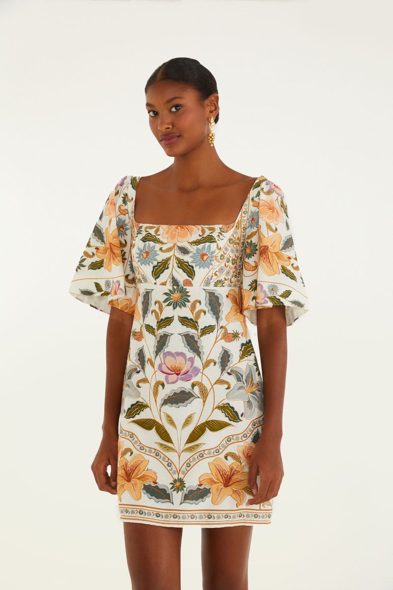Vestido corto con mangas abullonadas y estampado floral en tonos vibrantes, visto de lado.
