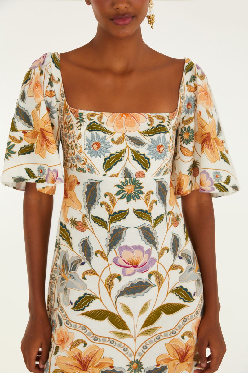 Vestido corto con mangas abullonadas y estampado floral en tonos vibrantes, visto desde atrás.
