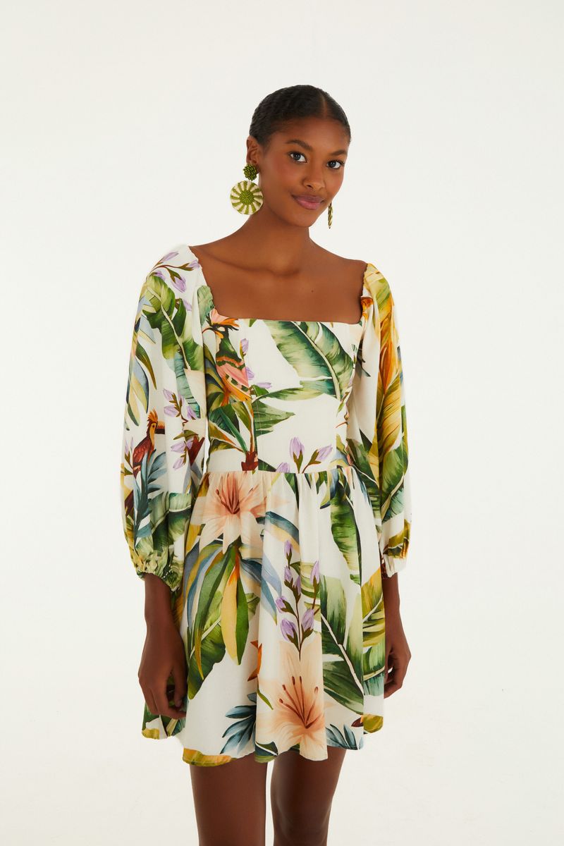 Vestido corto con estampado tropical, mangas largas y escote cuadrado, visto de frente.