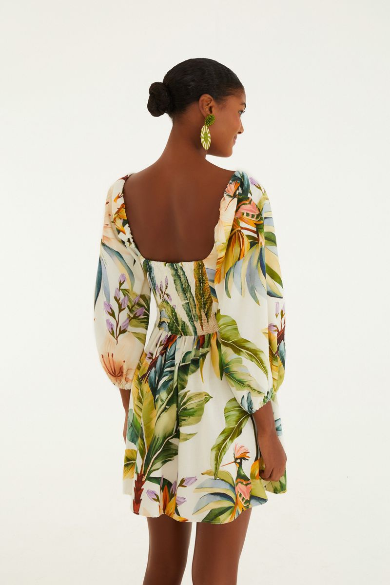 Vista lateral del vestido corto con estampado tropical, destacando el escote y las mangas.