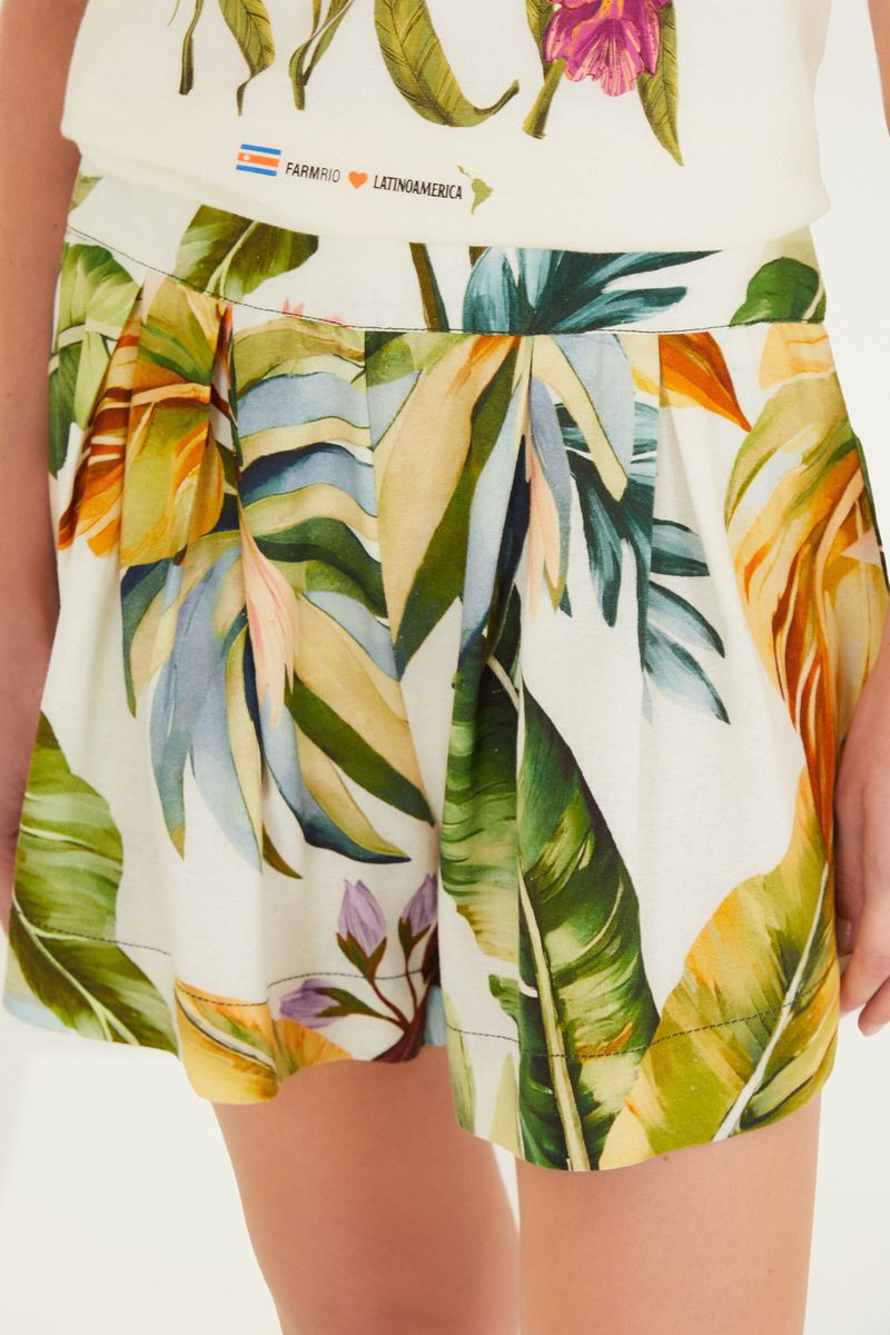 Primer plano de la pretina del pantalón corto con botón y estampado tropical.