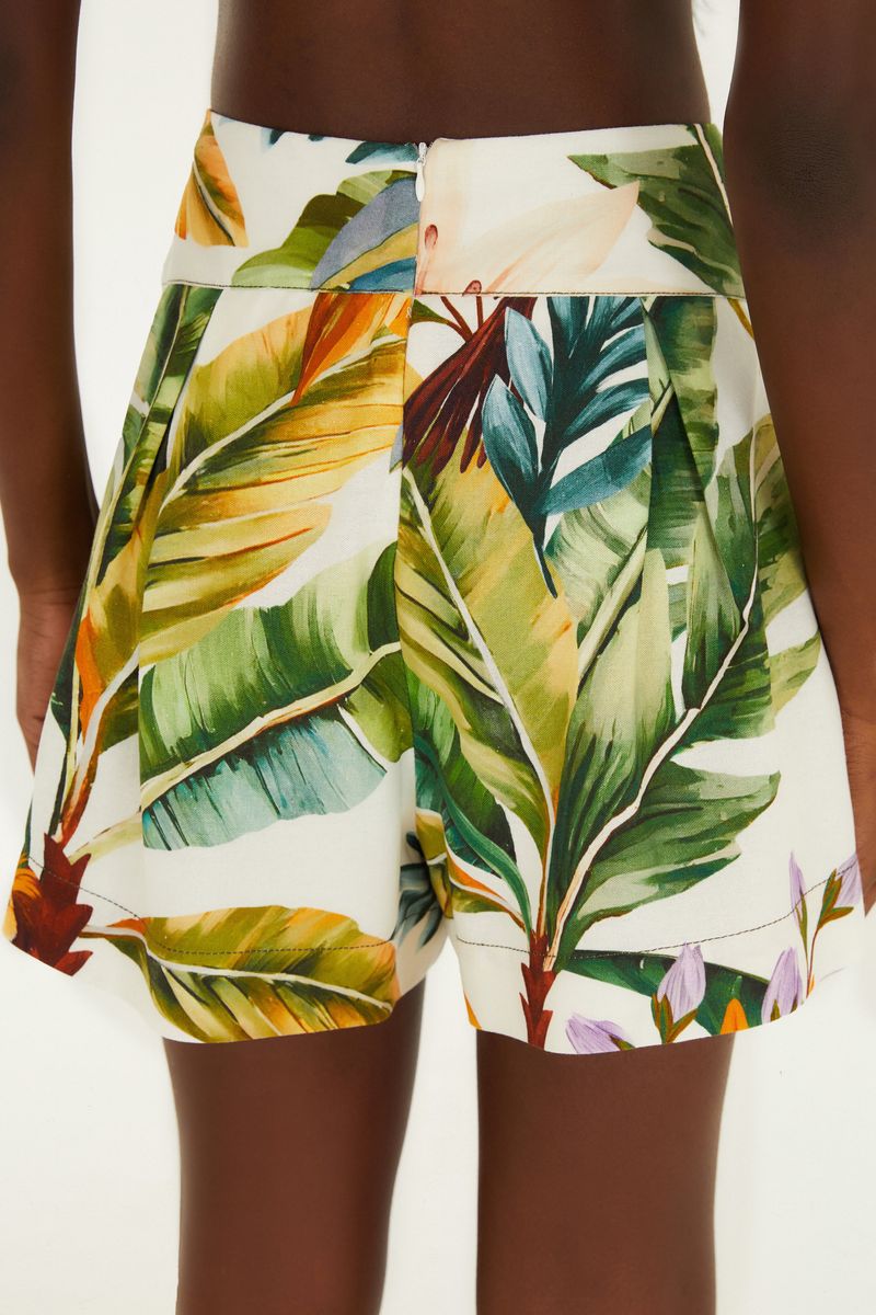 Detalle del estampado tropical con hojas y colores vibrantes.