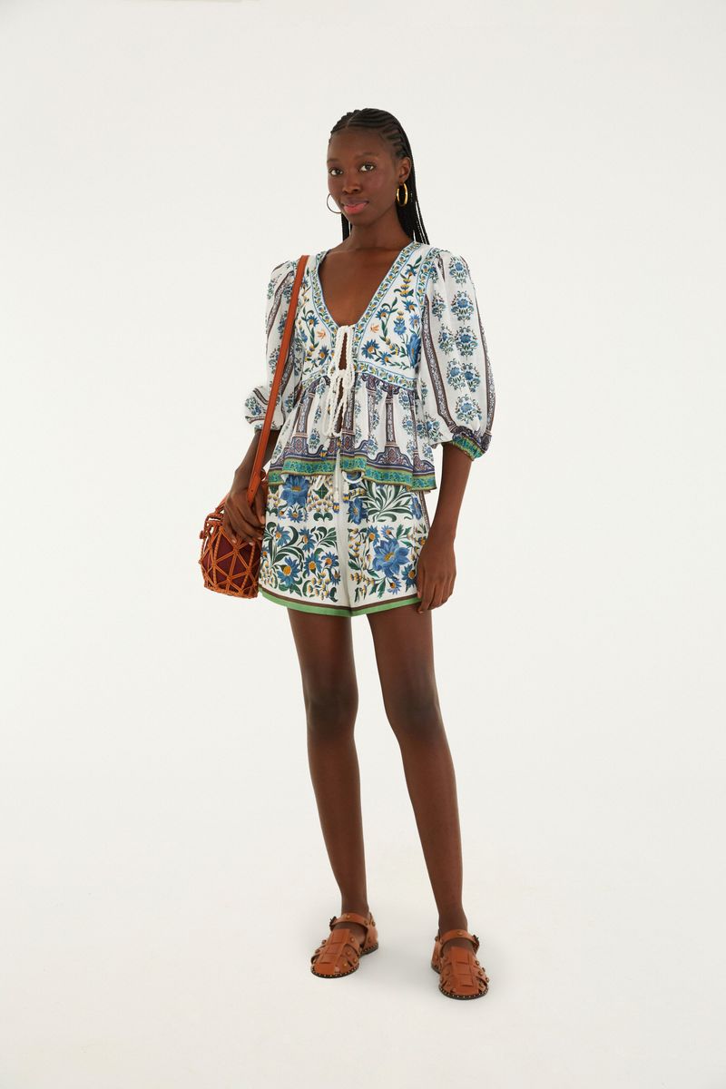 Modelo vistiendo blusa estampada con amarre y shorts combinados, vista completa.