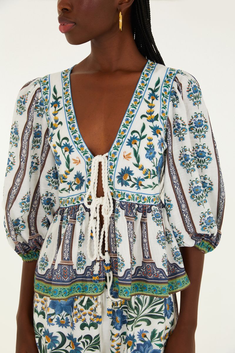 Detalle del escote en V y amarre frontal de la blusa estampada.