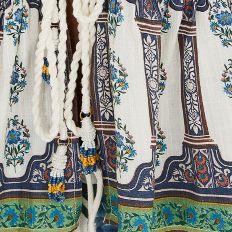 Close-up del estampado floral y amarre decorativo de la blusa.