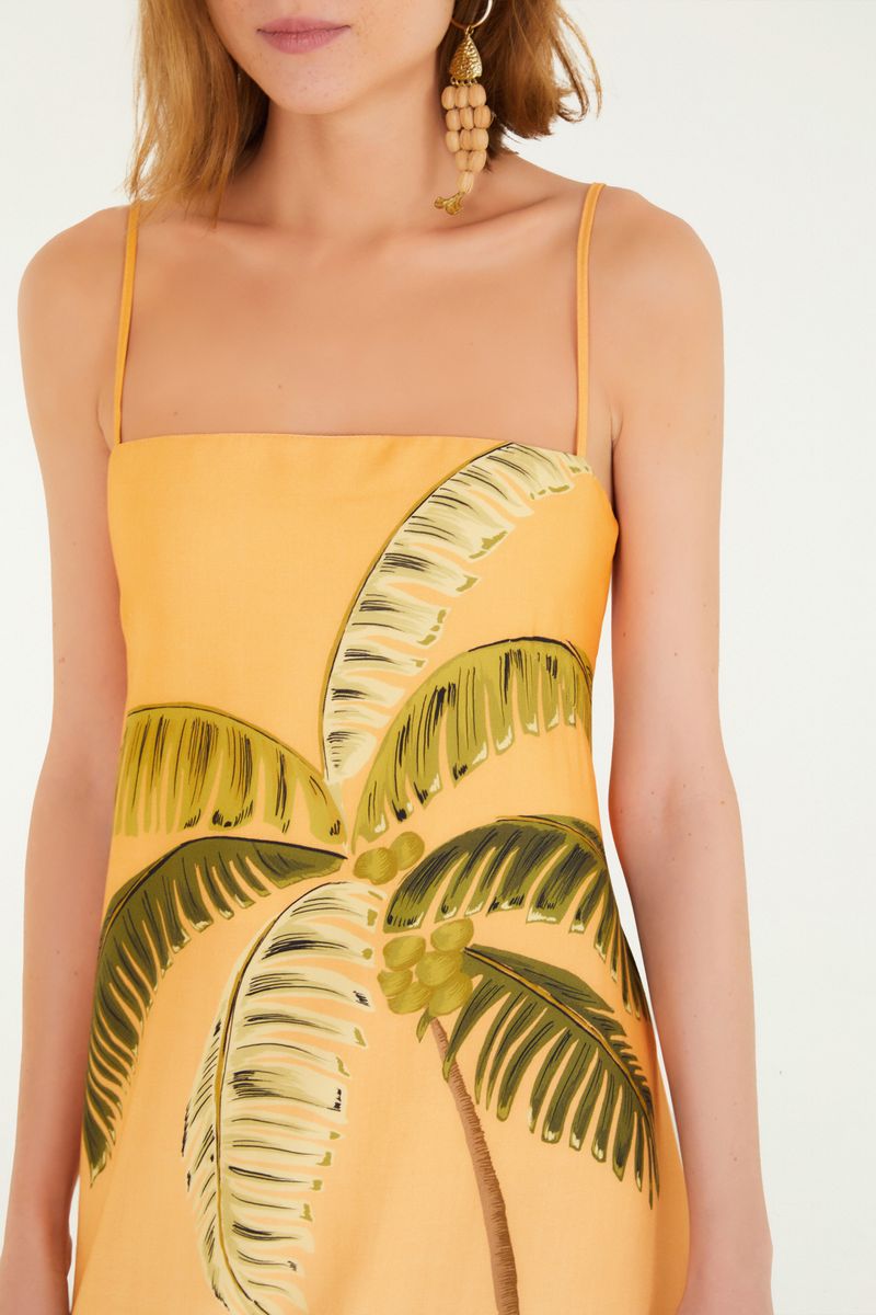 Detalle frontal del vestido mostrando el estampado de palmeras y el escote recto.