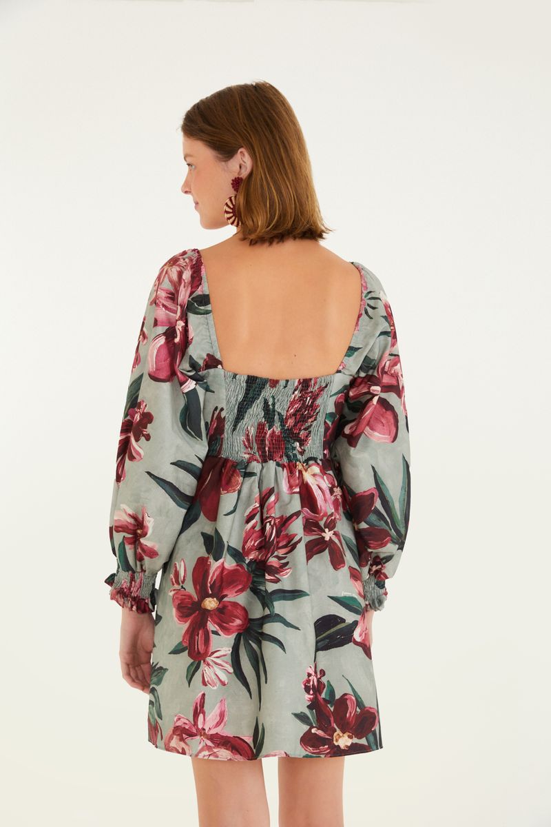 Vista trasera del vestido corto con estampado floral, mostrando el detalle del elástico en la parte trasera.