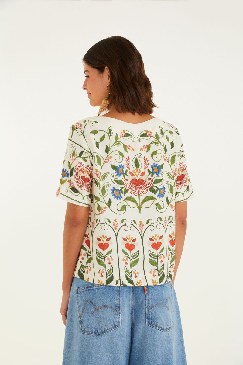 Vista trasera de la camiseta mostrando la continuidad del estampado floral.