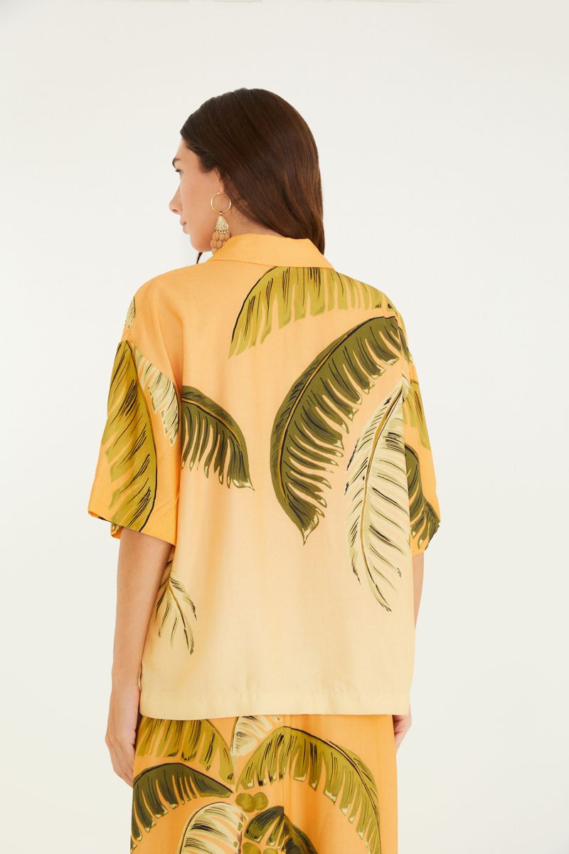 Vista trasera de la camisa tropical con estampado de palmeras.