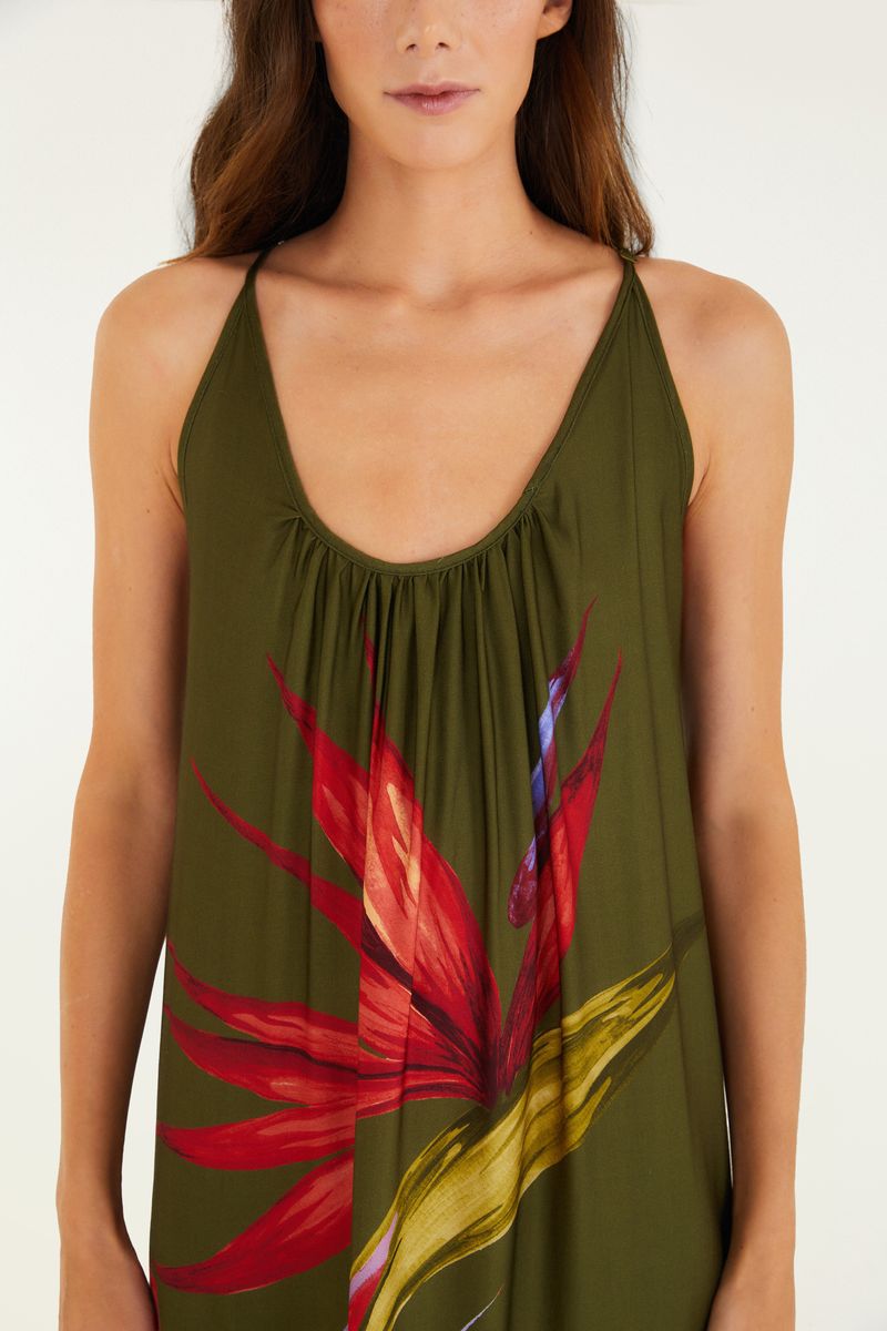Detalle del escote del vestido largo maxi con estampado de flores sobre fondo verde.