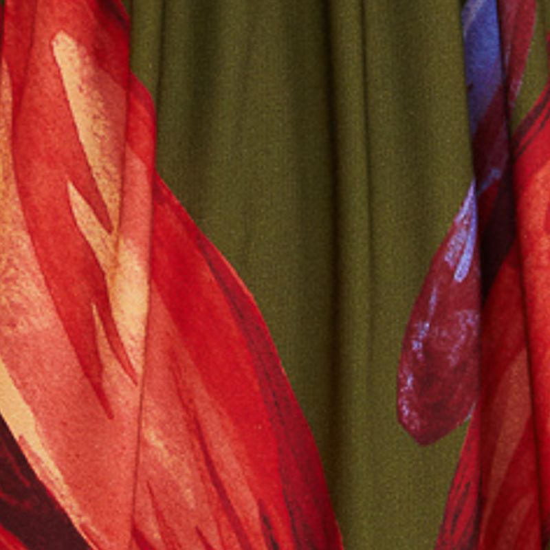 Primer plano del estampado floral del vestido largo maxi sobre fondo verde.
