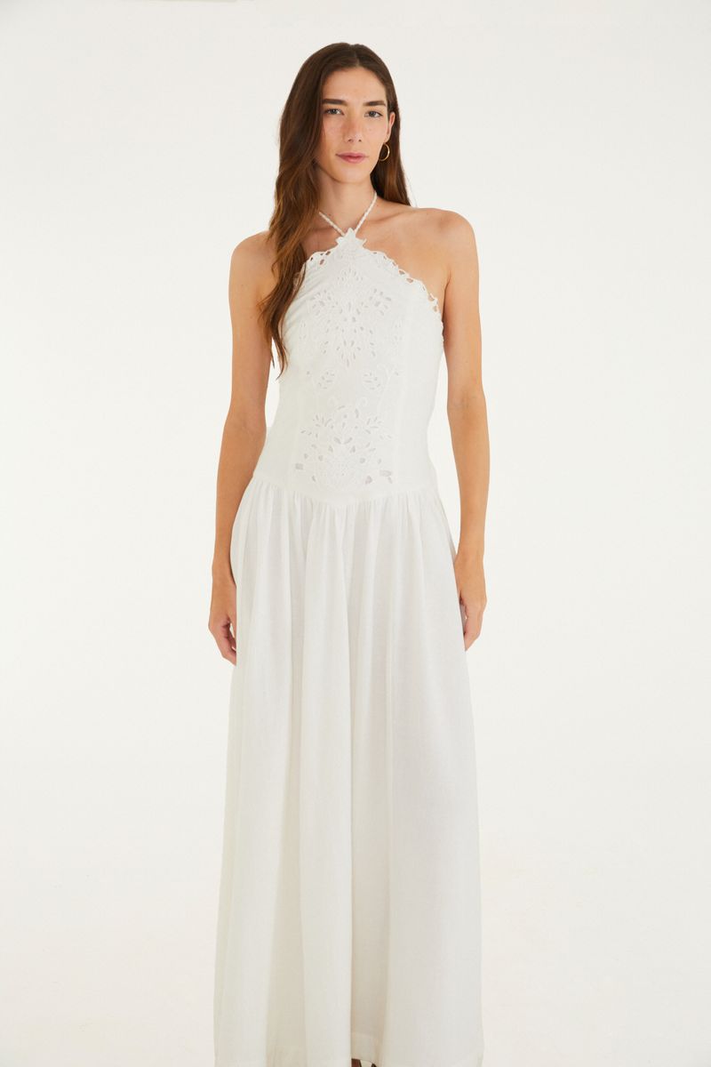 Vestido blanco largo con detalles bordados, visto desde el costado.