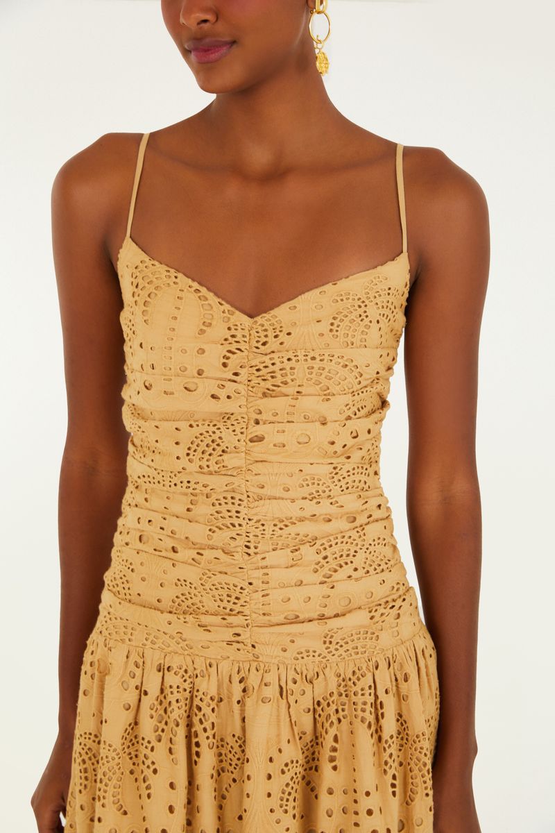 Vista de cerca del cuerpo fruncido del vestido con detalles de bordado calado.