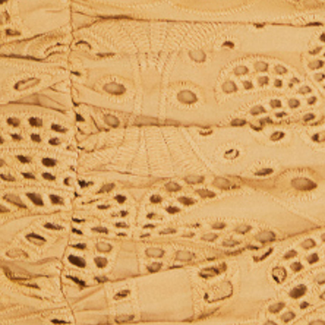 Detalle de la tela del vestido mostrando el bordado calado.