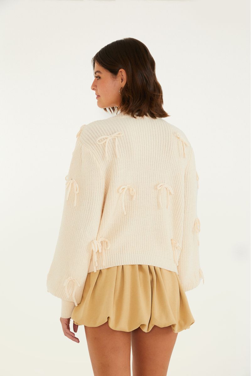 Vista trasera del cárdigan de tricot beige con lazos.