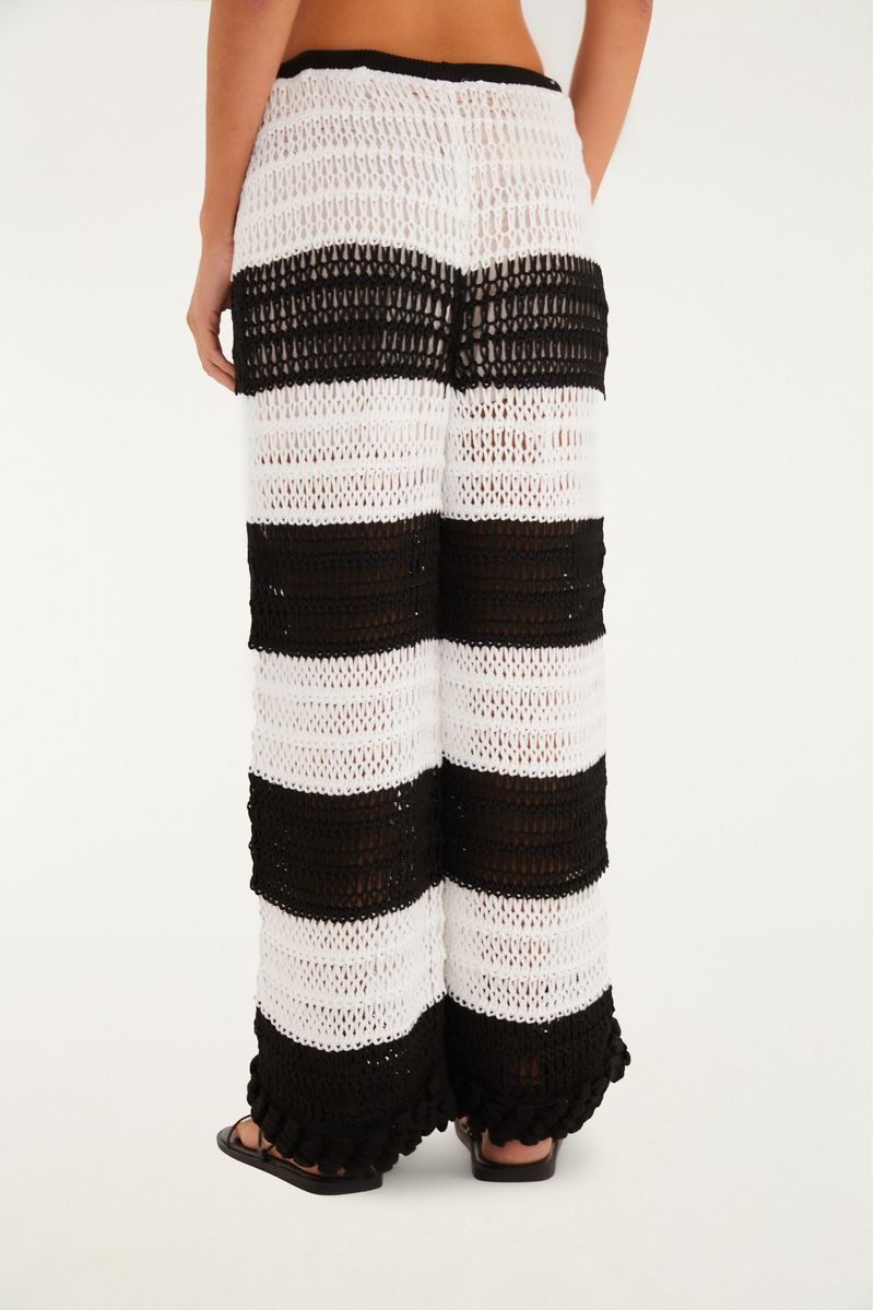 Imagen detallada del borde del pantalón de tejido de punto texturado con diseño de rayas en blanco y negro.