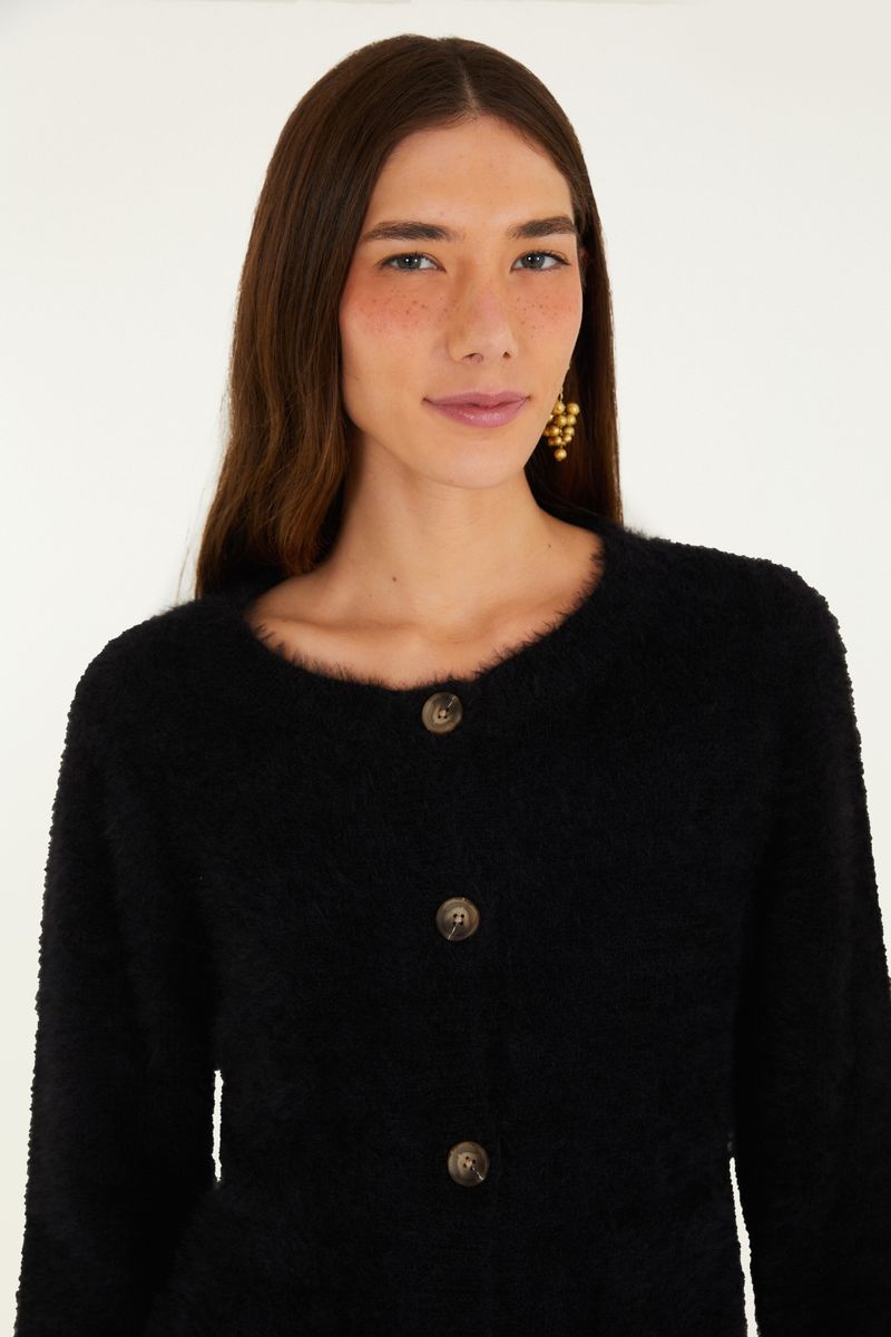 Detalle de los botones del cardigan negro corto con textura de pelito.