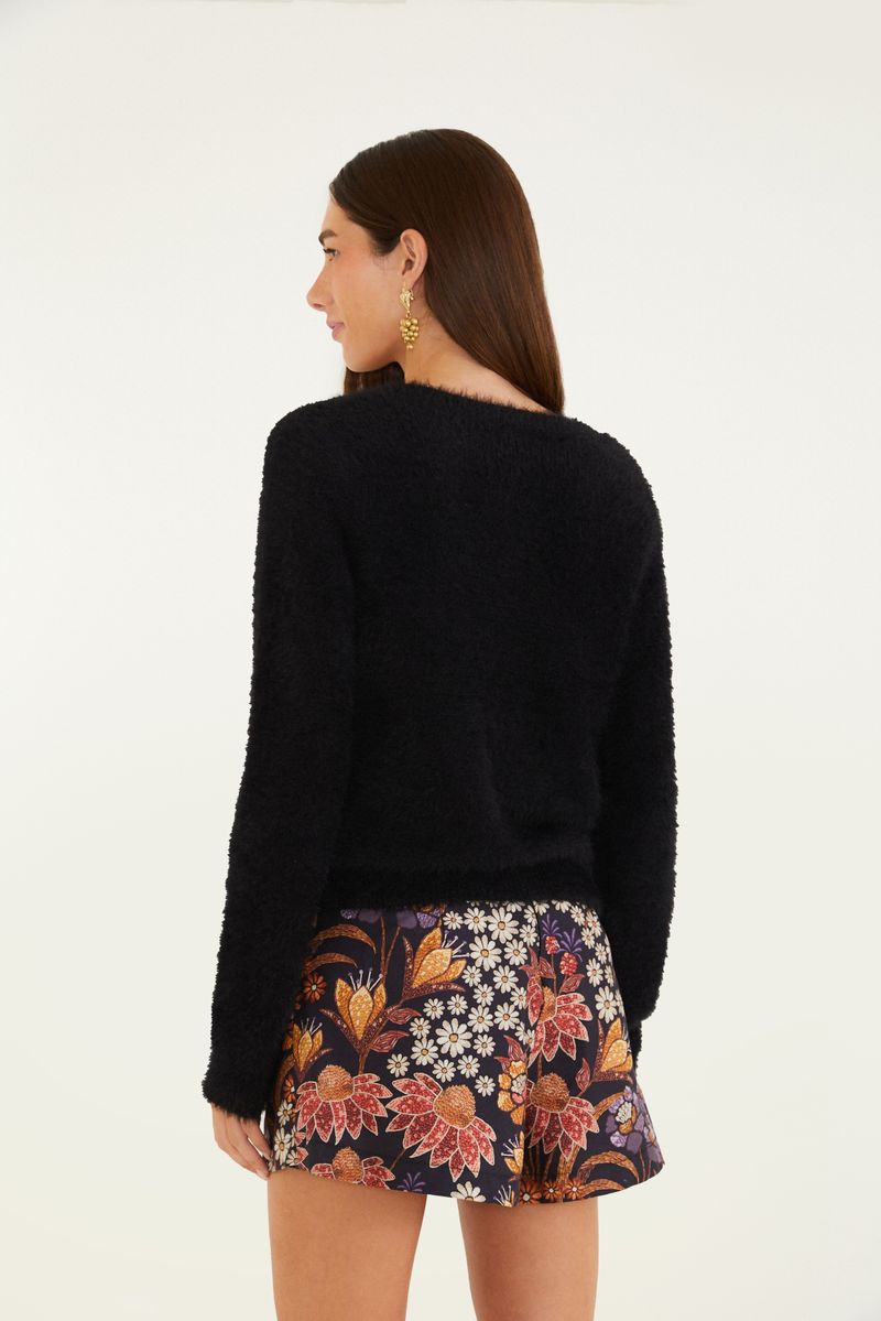 Cardigan negro corto con textura de pelito, visto desde atrás.