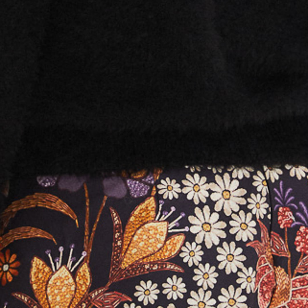 Detalle de la textura de pelito del cardigan negro corto.