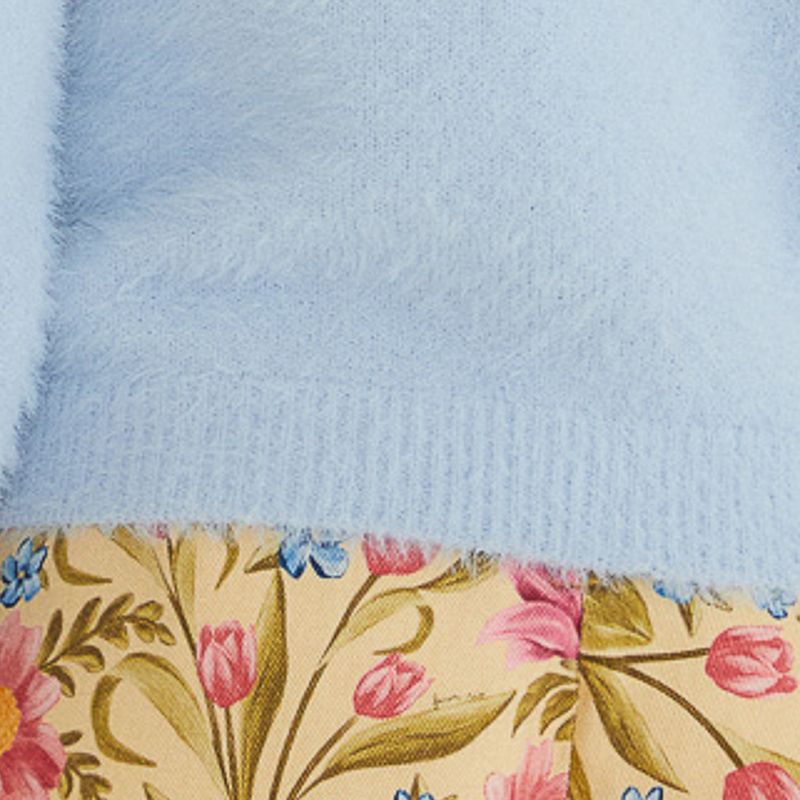Acercamiento a la textura suave del cardigan azul claro.