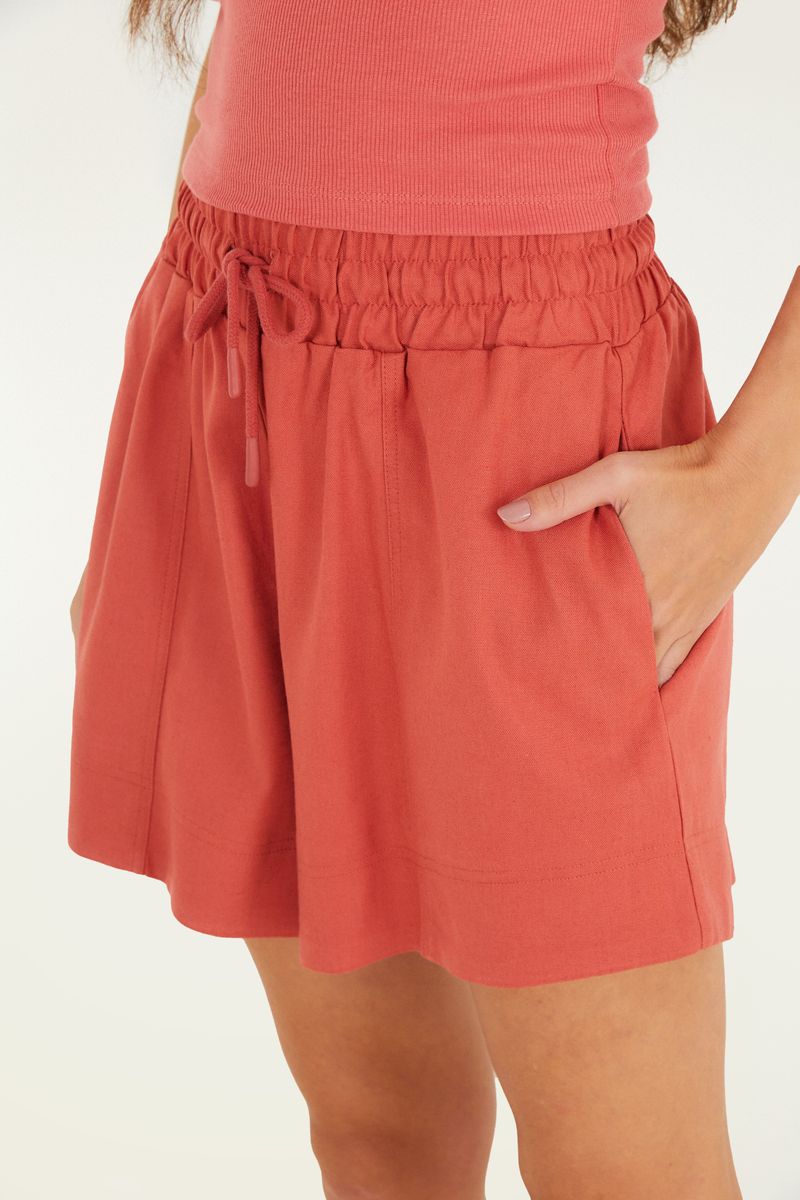 Acercamiento del short rojo mostrando el detalle del elástico y el cordón en la cintura.