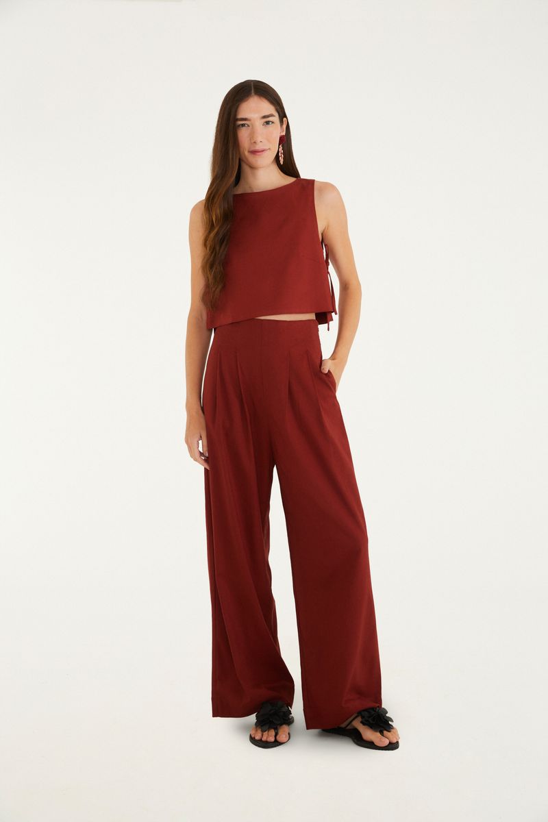Modelo vistiendo pantalón de sastrería recto rojo con top corto combinado, vista frontal.