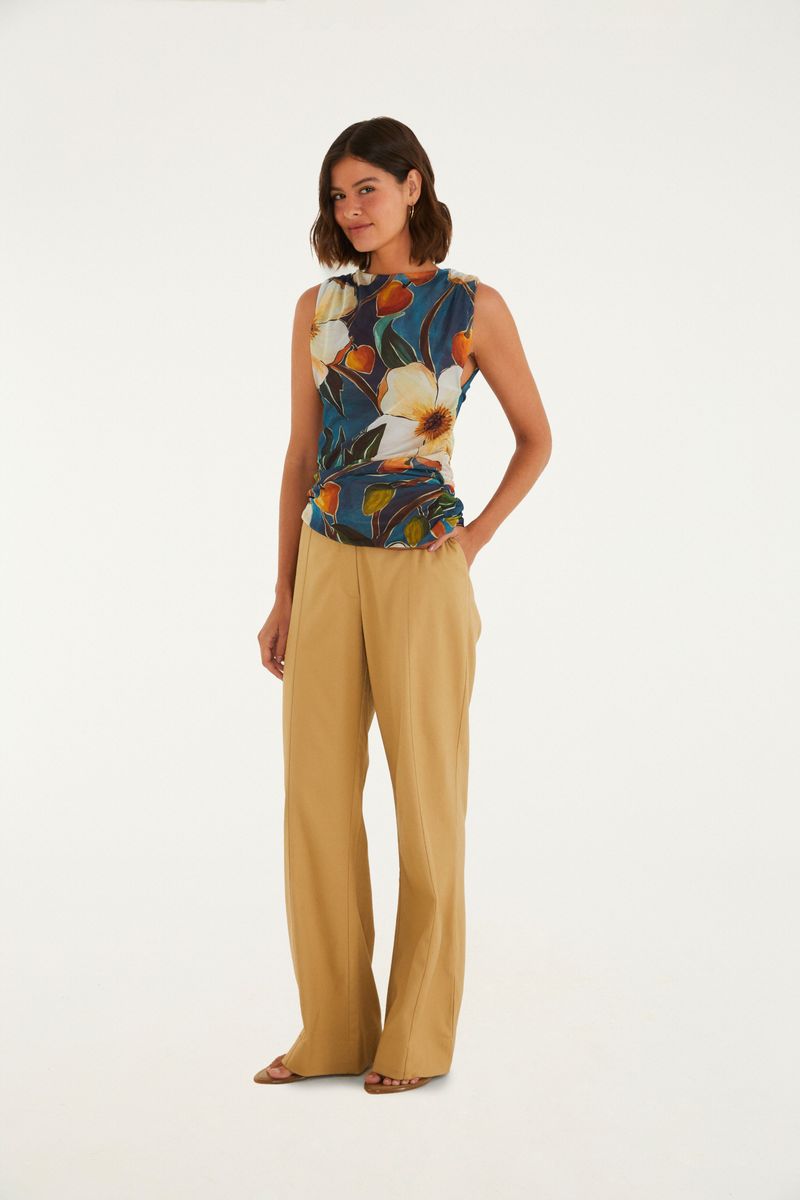 Modelo vistiendo pantalón de sastrería flare caramelo con blusa floral.