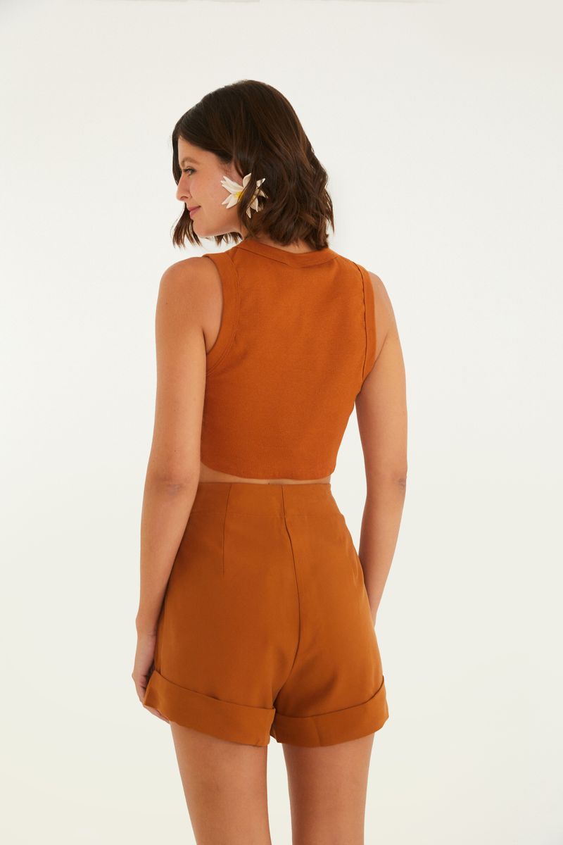 Imagen de un short de alfaiataria color ocre visto desde atrás, destacando el diseño limpio y elegante.