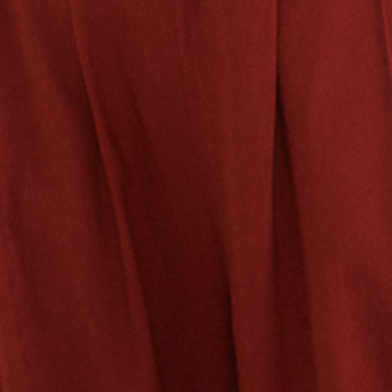 Modelo vistiendo pantalón de sastrería recto rojo con top corto combinado, vista lateral.