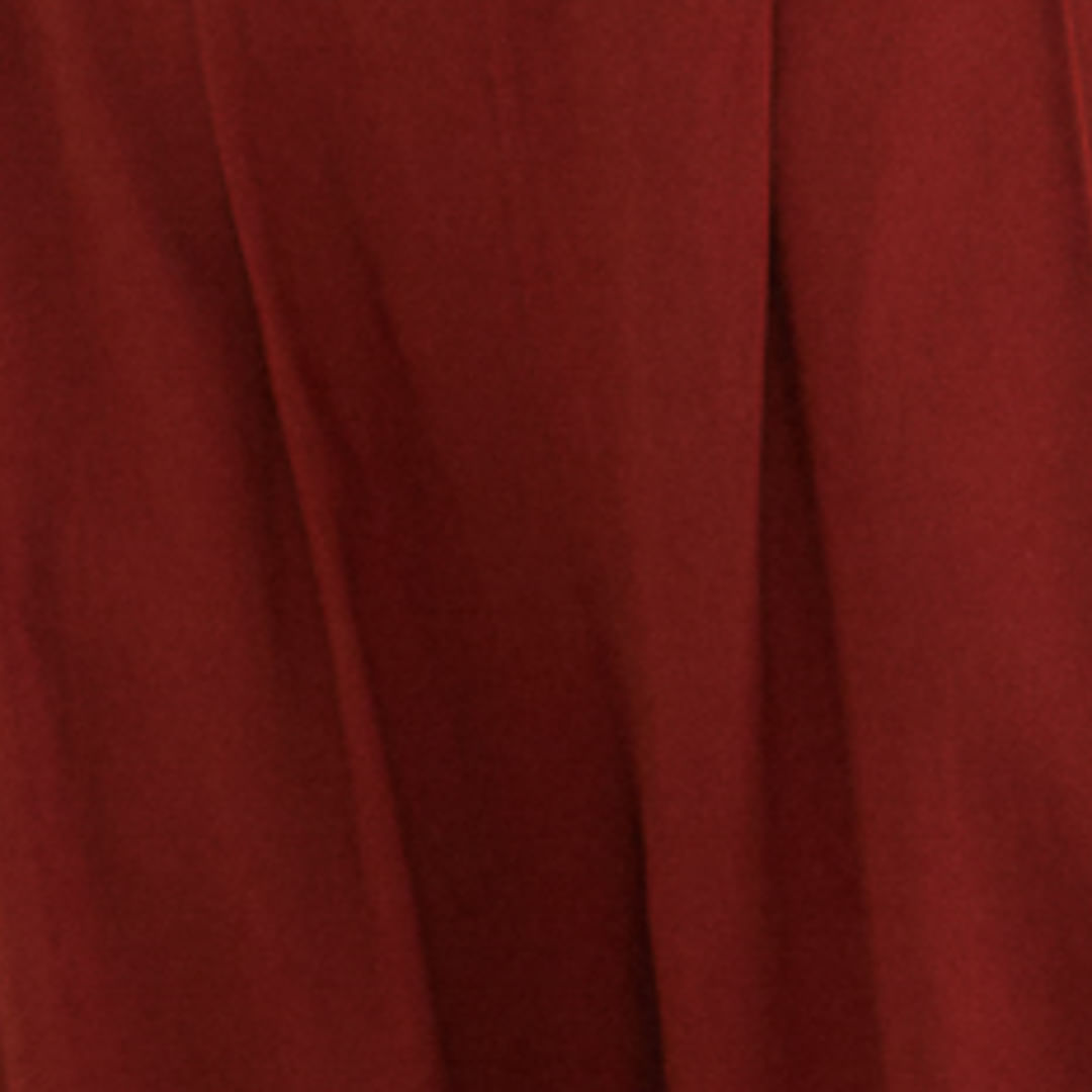 Modelo vistiendo pantalón de sastrería recto rojo con top corto combinado, vista lateral.