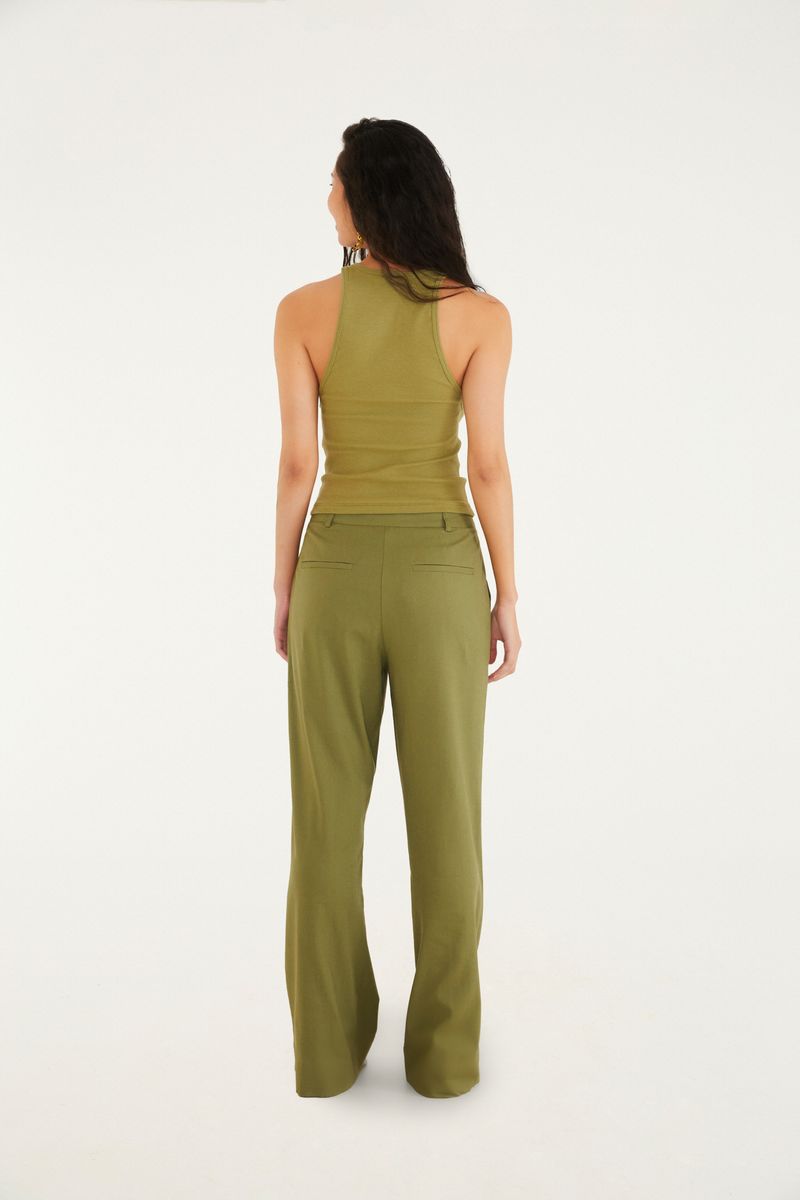 Detalle de la tela verde sólido del pantalón de sastrería flare.