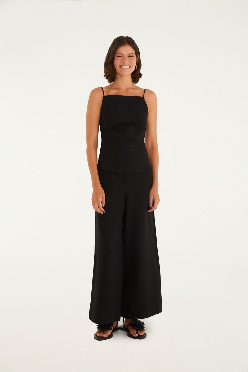 Modelo usando pantalón ancho de sastrería negro, vista frontal.