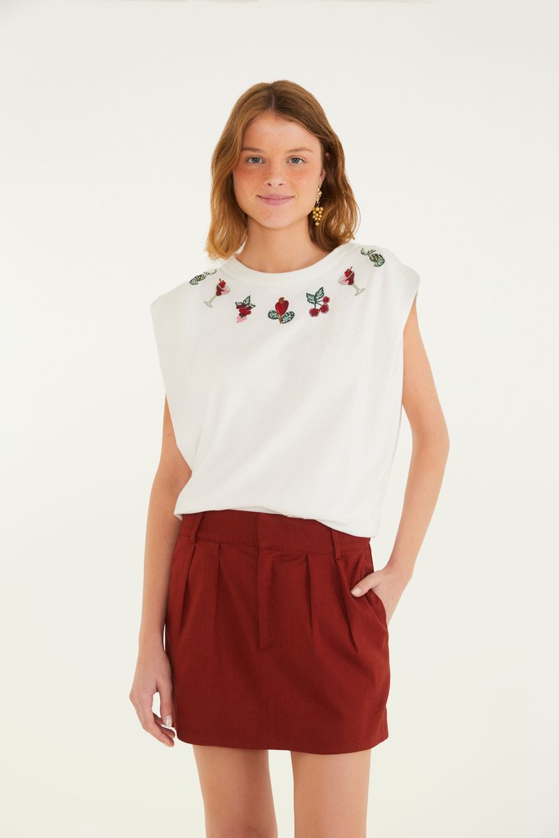Modelo usando falda corta alfaiataria roja con blusa blanca.
