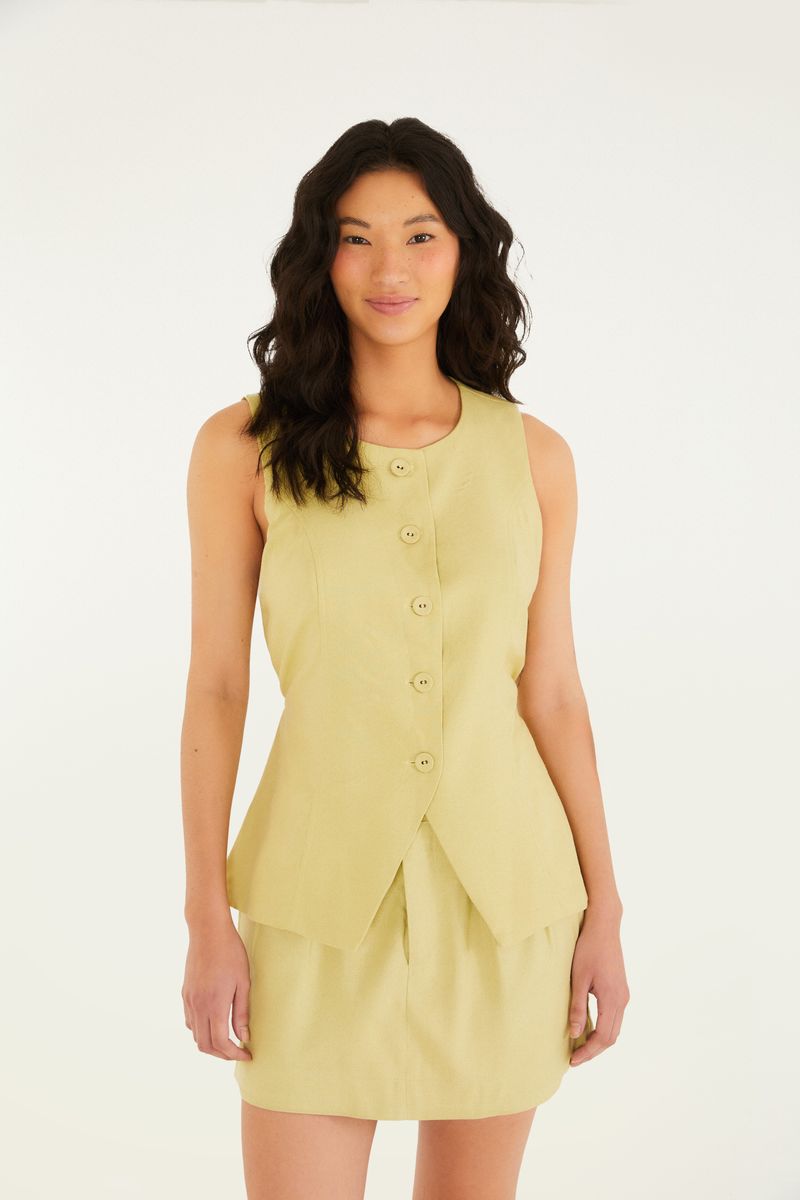 Modelo vistiendo un conjunto de sastrería amarillo claro, que incluye un short falda.