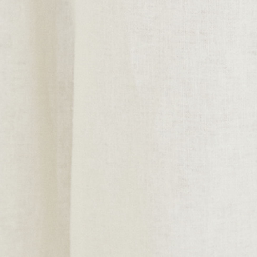 Detalle del tejido beige del pantalón amplio de sastrería.