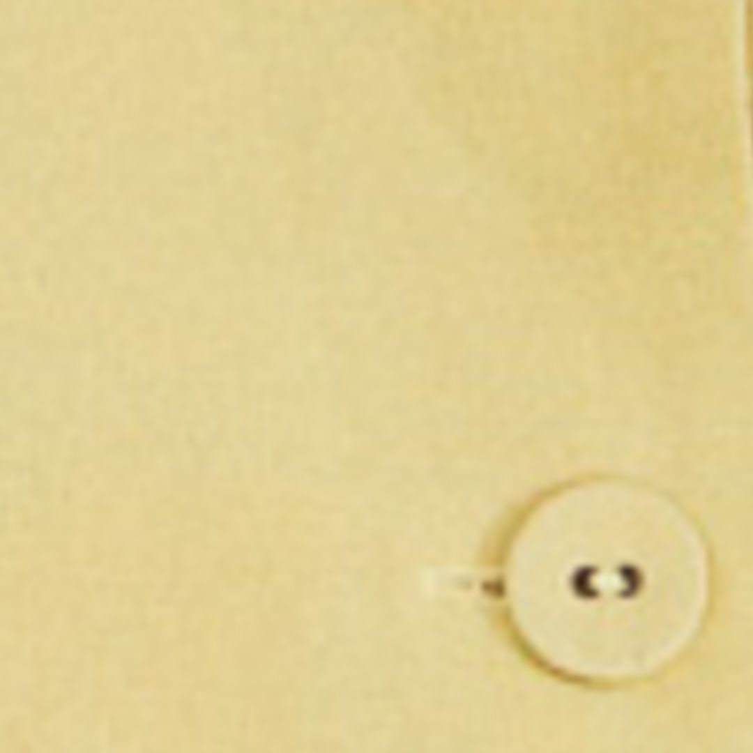 Detalle del botón del short falda amarillo claro mostrando el acabado.