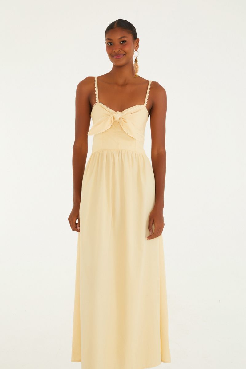 Imagen de un vestido largo con tirantes y lazada frontal, visto desde atrás.
