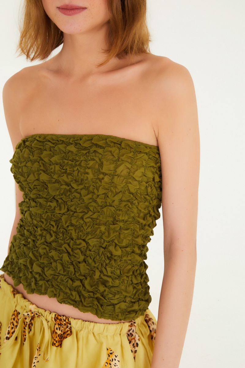 Detalle del tejido lastex de la blusa sin tirantes en verde.