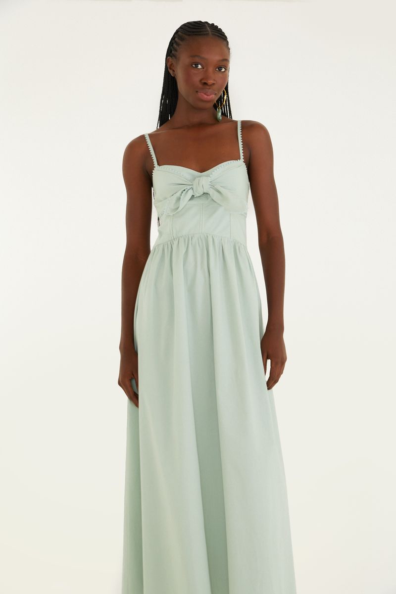 Vestido largo con tirantes y ajuste frontal en tono verde claro, visto de espaldas.