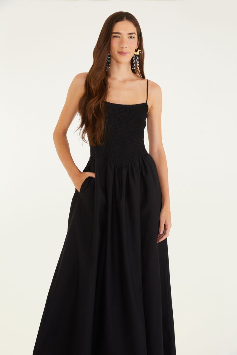 Primer plano del vestido negro mostrando el corpiño con textura de lastex y la falda larga.
