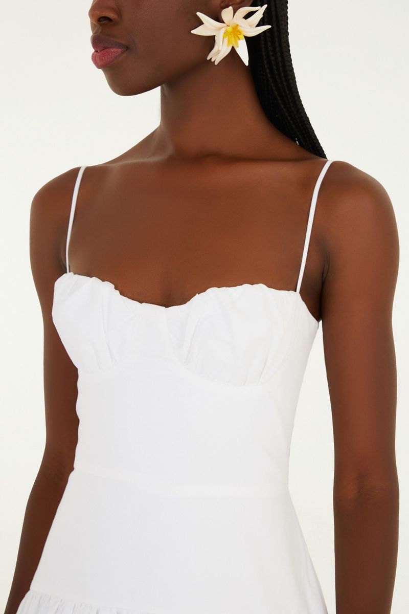 Detalle del corpiño del vestido blanco con tirantas delgadas y diseño balón.