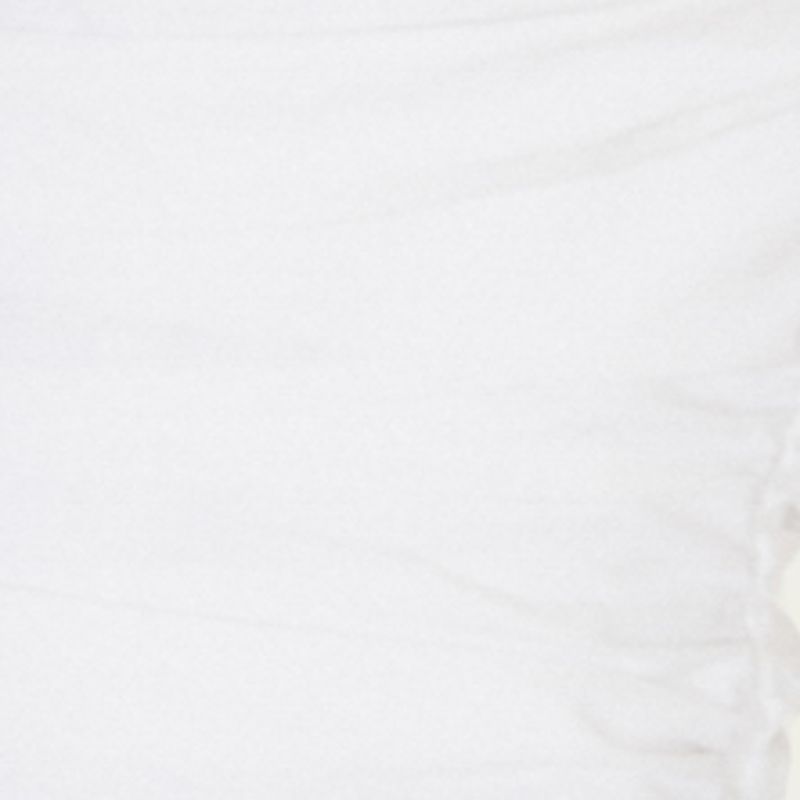 Close-up de la falda larga en capas del vestido sin tirantes blanco.