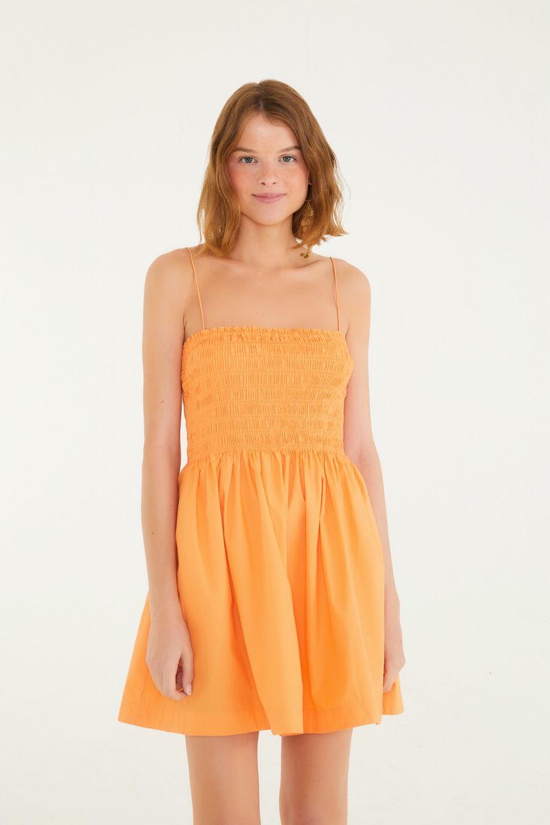Vestido corto con elástico y tirantes en tono naranja, visto de frente.